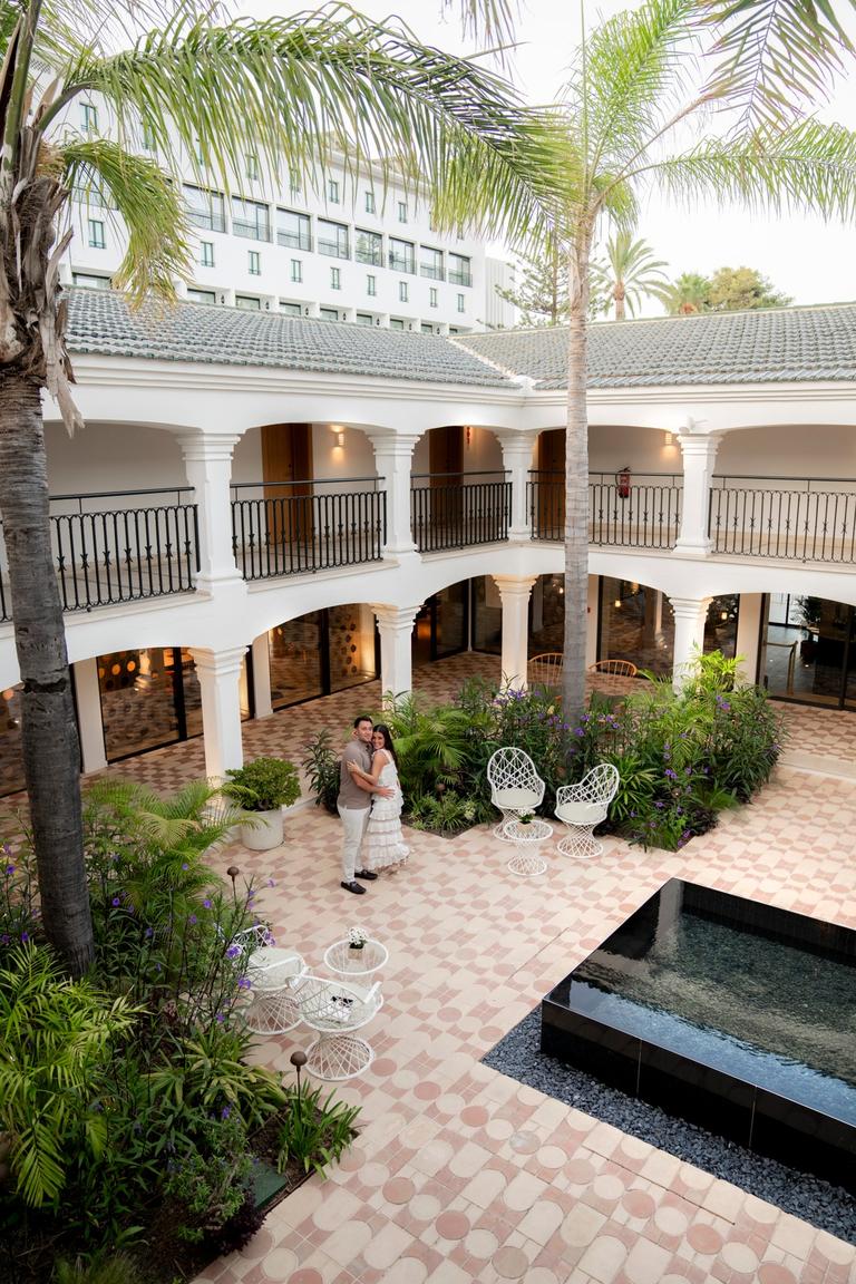 Couple embracing in a courtyard garden, seen from a balcony above